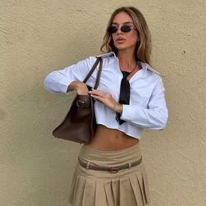 Schickes weißes kurzes Hemd mit Krawatte und khakifarbenem Faltenrock im Streetstyle