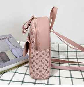 Detail view of pink mini backpack with litchi texture and brown clover floral pattern