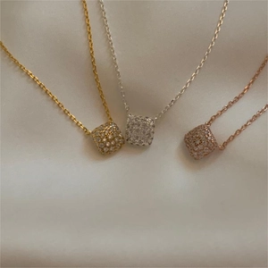 Detailed macro view of square micro-pave pendant necklaces in gold, silver, and rose gold