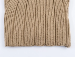 Macro shot of vertical ribbed knit texture and hem detail on beige cardigan set