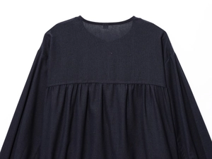 Detailed close-up of back yoke and box pleat on dark blue linen blend jacket