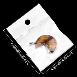 Tiger Eye crescent moon crystal pendant with metal clasp on a black background