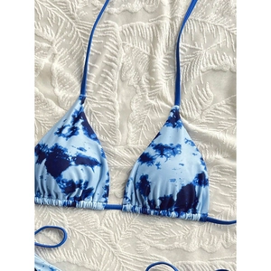 Close-up of tie-dye bikini top with halter neck strings and ruched drawstring detail