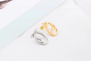 Macro shot of swan-shaped earrings with white enamel wings and sparkling zircon