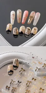 Macro detail of golden bow nail art stickers with embossed foil texture and floral designs