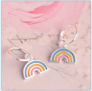Macro view of two S925 silver rainbow pendants with colorful enamel on a pink floral background