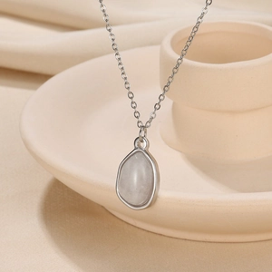 Macro detail of geometric silver chain and waterdrop pendant with translucent grey stone