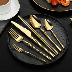 6-piece gold 304 stainless steel cutlery set with mirror finish on a black dinner plate