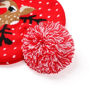 Gros plan d'un bonnet de Noël tricoté avec pompon rouge et motif de renne détaillé
