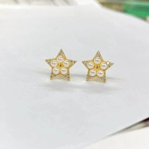 Gold plated star-shaped stud earrings featuring small faux pearls and shimmering accents