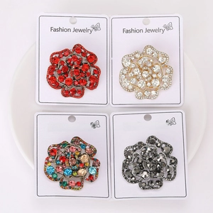 Detailed grid view of four crystal rose brooches in red, gold, multi-color and grey