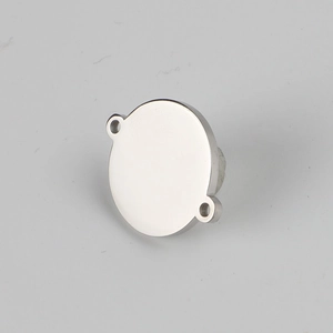Close-up of polished stainless steel round tag charm with dual holes for DIY jewelry