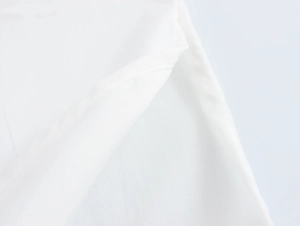Detailed close-up showing the fine stitching and white fabric texture of the resort set