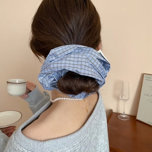 Close-up of blue plaid scrunchie styled on a bun hairstyle with Korea label detail