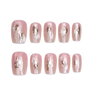 Faux ongles œil de chat roses avec accents de feuilles d'or et design graffiti blanc