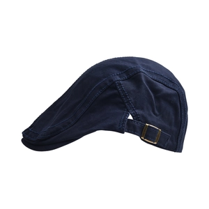 Detail of adjustable bronze metal buckle on navy blue cotton canvas beret hat