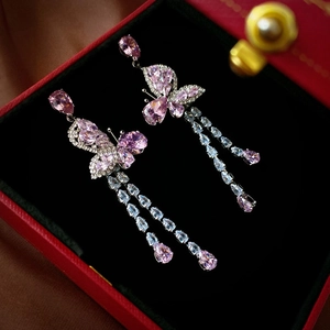 Elegant zircon butterfly earrings with pink water drop tassels on a luxury red jewelry box