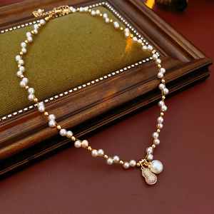 Detail of lobster clasp and adjustable extension chain on gold pearl necklace