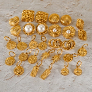 Flat lay of vintage gold-plated stainless steel earrings with pearls and geometric patterns