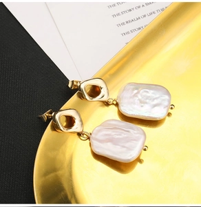 Macro shot of natural baroque pearls on a gold frame displayed on a luxury metal tray