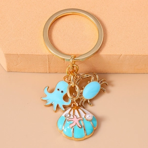 Cartoon ocean animal keychain with blue octopus, crab and shell charms in gold metal