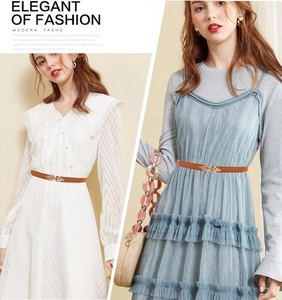 Detail of a slim brown elastic waist belt with a golden leaf buckle on various dresses