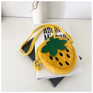 Detail of yellow plush strawberry crossbody bag with green leaves and woven rope strap
