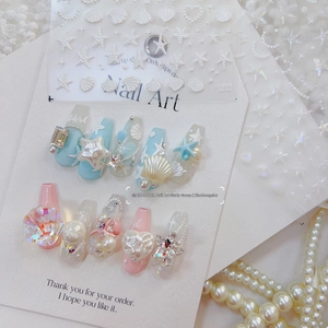 Detailed view of 3D shell and starfish decorations on long trapezoid press-on nails