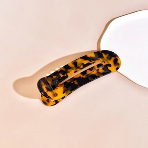 Detailed view of vintage tortoiseshell hair claw clip with amber and black acetate pattern