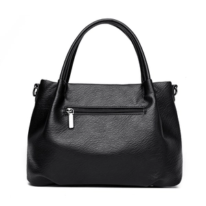 Grande borsa a mano nera in pelle martellata con zip posteriore su sfondo bianco