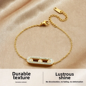 Detailed close-up of gold-plated stainless steel bracelet with three zircon stones