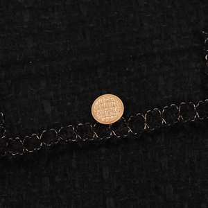 Abito smanicato in tweed nero stile francese con bottoni dorati e finiture intrecciate