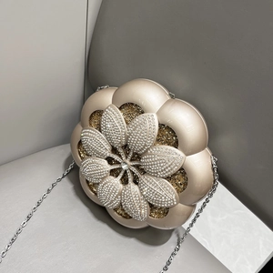 Detail of flower-shaped champagne gold evening bag with rhinestones and metal chain