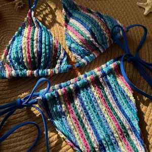 Détail d'un bikini en crochet coloré montrant des rayures et l'anneau ambré