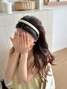 Close-up of a minimalist pale yellow textured headband on a model in a Korean style setting