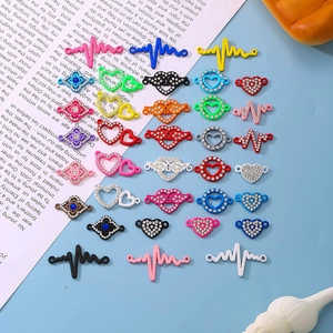 Colorful alloy heart and lightning bolt jewelry connectors on a flat lay blue background