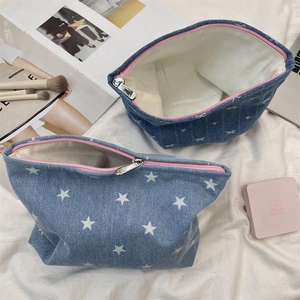 Détail de trousses à maquillage en denim avec zips roses et motifs imprimés