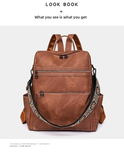 Detail of vintage brown leather backpack with ethnic floral strap and multiple zippers