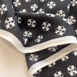 Close-up of black and white floral pattern square scarf with twill weave and white piping