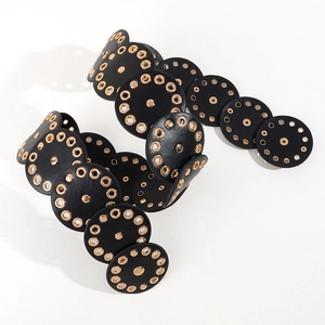 Detail of vintage black leather disc belt with gold metal eyelets and snap buttons