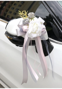Detail of white Austin rose wedding car decoration with elegant flowing silk ribbons