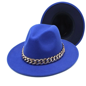 Detail of royal blue fedora hat with a bold gold acrylic chain on clean white background