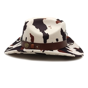 Detailed view of cow print cowboy hat with bull head metal buckle and rivets