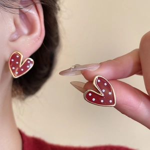 Detail of vintage red heart stud earrings with white polka dots and gold metallic edges