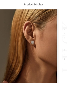 Close-up of emerald cut moissanite stud earrings on model with silver halo design