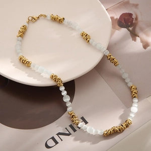 Détails des perles dorées bohèmes et des pierres oeil-de-chat blanches sur le collier