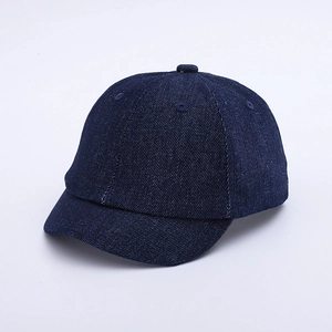 Detail view of the short brim and six-panel stitch construction on the navy denim baby cap
