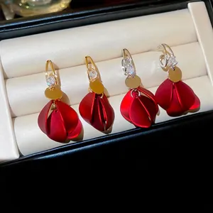 Elegant red matte petal earrings with zircon accents and tassels in a jewelry box