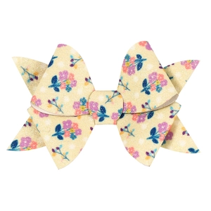 Detailed close-up of a sequin glitter bow hair clip with floral and polka dot prints
