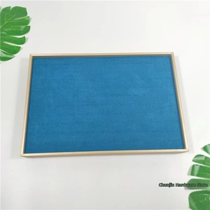 Close-up of gold metal frame jewelry display tray with blue velvet ring slots